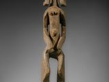 une sculpture en bois représentant un homme portant une femme sur son dos