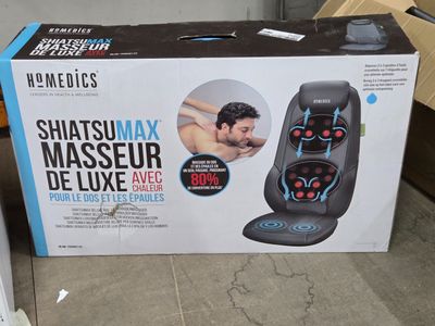 une boîte posée par terre, contenant un appareil de massage