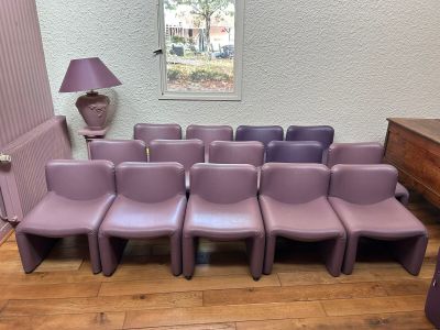 many purple chairs in a room with a lamp on