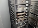 many trays of food on a metal rack in a room