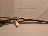 un vieux fusil avec un canon en bois et une poignée en bois