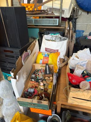 Des cartons contenant des objets divers sont posés sur une table dans une pièce encombrée