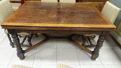 a wooden table with four chairs around it in a room
