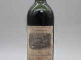 une vieille bouteille de vin posée sur une table blanche