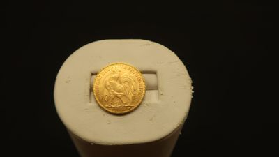 a gold coin sitting on top of a white object