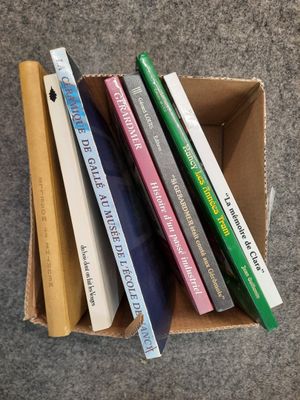 une boîte remplie de livres empilés les uns sur les autres