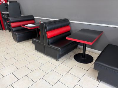 une banquette rouge et noire avec deux chaises et une table