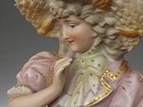 a figurine of a woman wearing a hat and holding a fan