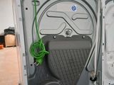 an open refrigerator with the door open and a green hose attached to it