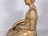 an image of a gold statue of a woman sitting on a rock