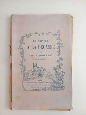 un vieux livre posé sur une table à côté d'un mur blanc
