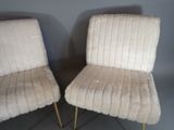 pair of cream colored chairs with gold metal legs