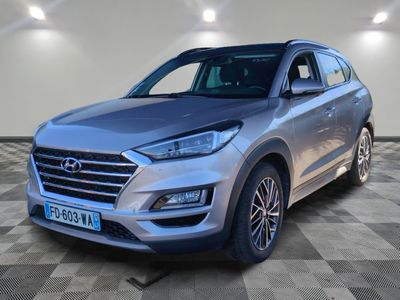 un SUV argenté garé sur un sol en damier dans un garage