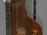 un vieil instrument de musique avec un corps en bois et des cordes, sur fond gris