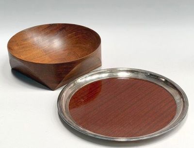 a wooden bowl and a silver plate on a white surface