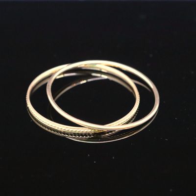 a close up of two gold rings on a black surface