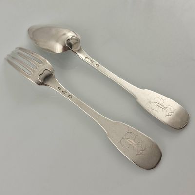 two spoons and a fork sitting on a table