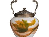 a vase with a handle that has a leaf on it
