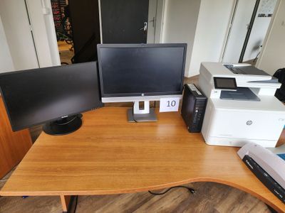 a desk with two monitors and a printer on it