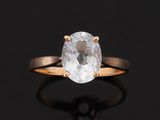 une bague en diamant blanc avec un anneau en or sur fond noir