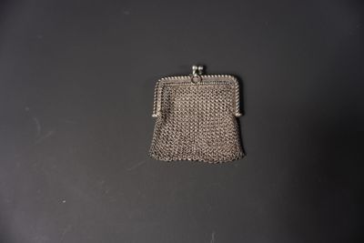 un petit sac à main argenté posé sur une table noire