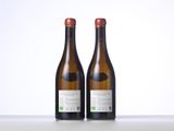 two bottles of wine sitting on top of a table next to each other