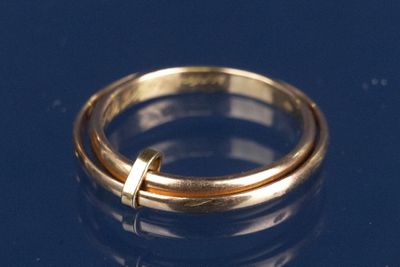 une bague en or ornée d'une croix sur un fond bleu