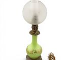a green lamp that has a glass shade on it