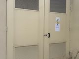 two doors on the side of a building that has a sign on it
