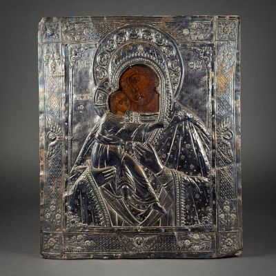 an old silver metal plaque with an image of a woman holding a child