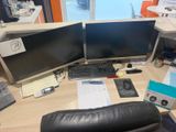 un bureau sur lequel sont posés deux écrans d'ordinateur et un clavier