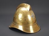 brass helmet with cross on it on a gray background