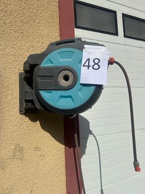 un tuyau fixé sur le côté d'un immeuble, sur lequel est accrochée une pancarte