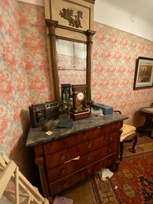 a dresser with a mirror on top of it in a room with floral wallpaper