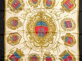 une écharpe blanche et dorée sur laquelle est représenté un blason