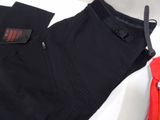 black pants and a red jacket are sitting on a white surface