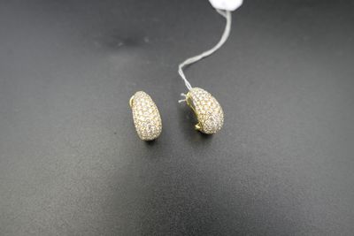 a pair of gold tone pave earrings on a black surface