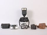 a lot of different types of cameras sitting on a table