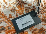 an orange and white floral print dress with a tag on it