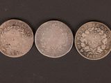 three different types of coins on a black surface
