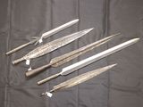 six knives are lined up on a table with a black cloth