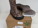 une paire de bottes à imprimé léopard posée sur une boîte en carton
