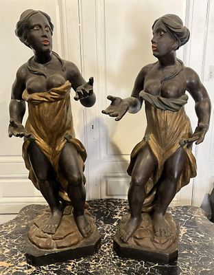 paire de statues en bronze représentant une femme et un homme, posées sur un socle en marbre