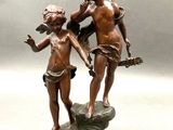bronze statue of a boy and a girl on a rock