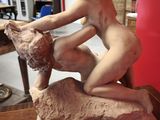 a statue of a woman sitting on top of a rock