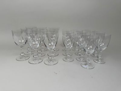 six clear wine glasses are lined up on a white surface