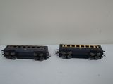 pair of black and gold train cars sitting on a white surface
