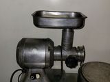 a meat grinder sitting on top of a metal table