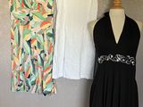 three dresses hanging on a clothes rack in front of a wall