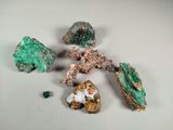 several different colored rocks on a white surface with a white background